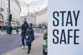  ?? ALBERTO PEZZALI/AP ?? Pedestrian­s keep their masks on outside Sunday as they make their way along Regent Street in London.