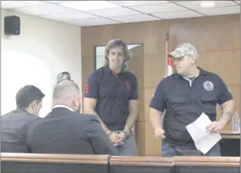  ??  ?? Carlos “Aquiles” Báez ingresa esposado a la sala de juicios orales para escuchar la sentencia que le condenó a 4 años y medio por incitación a cometer hechos punibles.