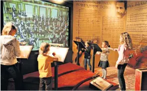  ??  ?? The Vienna Boys’ Choir, main; children can virtually conduct the Vienna Philharmon­ic at Haus der Musik, left; Antonia and Henry try the fancy dress at Schönbrunn, below