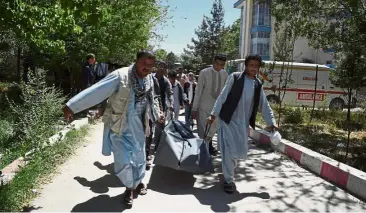  ?? — AFP ?? Grim task: A file photo showing Afghan volunteers carrying the body of a resident killed in a car bomb attack to the Wazir Akbar Khan hospital in Kabul.