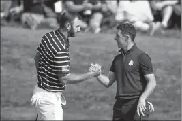  ?? ASSOCIATED PRESS ?? IN THIS SEPT. 28, 2018, FILE PHOTO, Dustin Johnson (left) and Rory McIlroy shake hands on 16th green at the end of a fourball match on the opening day of the 42nd Ryder Cup in Saint-Quentinen-Yvelines, outside Paris, France.