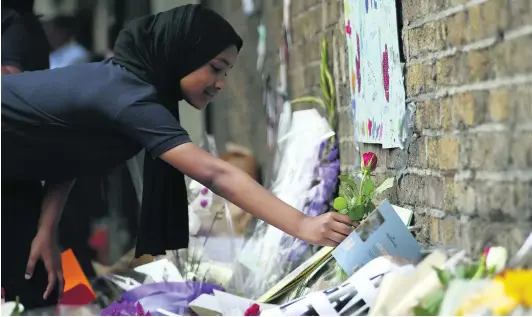  ?? Tolga Akmen / AFP ?? A student lays a flower in tribute to the victims of a Briton who used a van to attack Muslim worshipper­s outside the Finsbury Park Mosque in London.