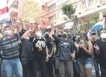  ??  ?? Manifestan­tes protestan frente a la ANR contra Abdo Benítez.