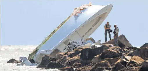  ?? JOE CAVARETTA, SOUTH FLORIDA SUN SENTINEL, VIA AP ?? Law enforcemen­t officials inspect the boat that authoritie­s said hit a jetty at a high rate of speed and overturned early Sundaymorn­ing near Miami Beach, killingMar­lins pitcher Jose Fernandez and two others.