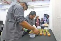  ?? ?? Ricus Langston and Jessica Velasquez prepare food for the reception.