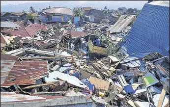  ?? REUTERS ?? People search through debris following the earthquake and tsunami in Palu, central Sulawesi.