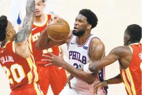  ?? JOHN BAZEMORE/AP ?? Sixers center Joel Embiid, with ball, is fouled by Hawks forward Tony Snell, right, as Hawks forward John Collins defends during Game 3 of a second-round playoff series Friday in Atlanta.