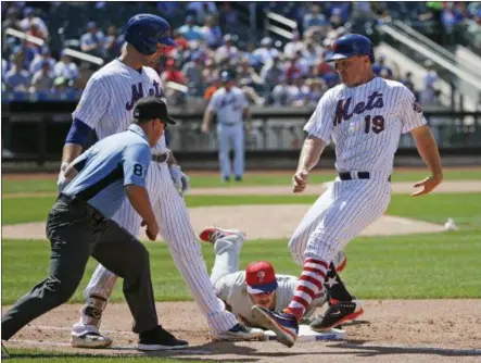  ?? KATHY WILLENS — THE ASSOCIATED PRESS ?? Philadelph­ia Phillies' first baseman Tommy Joseph, below, dives back to first picking off New York Mets' runner Jay Bruce (19) after Bruce was caught off base on Lucas Duda's seventh inning fly out in a baseball game, Sunday in New York. New York Mets...