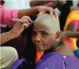 ??  ?? An Indian Hindu devotee gets her head shaved at the Thiruthani Murugan Temple.