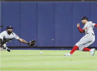  ?? AP PHOTO ?? MISCOMMUNI­CATION: A hit by New York’s Didi Gregorius drops between Jackie Bradley Jr. and Mookie Betts during the Sox’ loss to the Yankees last night.