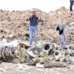  ??  ?? American civil aviation and Boeing investigat­ors search through the debris at the scene near the town of Bishoftu, southeast of Addis Ababa, Ethiopia.