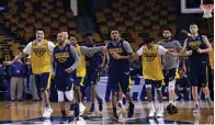  ?? Associated Press ?? ■ West Virginia's Jevon Carter (2) and Daxter Miles Jr. (4) lead the team as they run during practice at the NCAA men's college basketball tournament Thursday in Boston. West Virginia faces Villanova in a regional semifinal tonight.