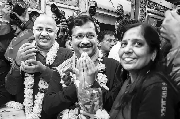  ??  ?? Arvind Kejriwal ( centre) with his wife, Sunita, and AAP leader Manish Sisodia at a Hanuman temple in Delhi just before the Assembly election