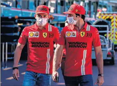  ??  ?? Charles Leclerc y Carlos Sainz, pilotos de Ferrari, caminan juntos por el ‘pit lane’ del circuito de Mónaco.