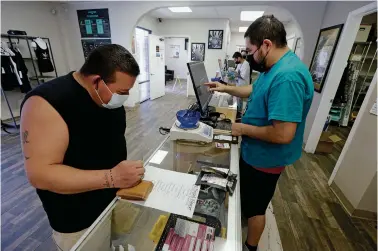  ??  ?? ABOVE: Matt Salas of Santa Fe, left, purchases some edibles last month from Eli Espinoza, manager at Ultra Health on St. Michael’s Drive.