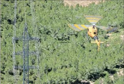  ?? MANÉ ESPINOSA ?? Un helicòpter d’Endesa comprova una torre elèctrica en una zona forestal de Callús, al Bages