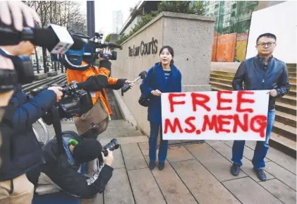  ?? JONATHAN HAYWARD/THE CANADIAN PRESS VIA AP ?? People hold a sign at a Vancouver, British Columbia, courthouse prior to a Monday bail hearing for Meng Wanzhou, Huawei’s chief financial officer. Meng Wanzhou was detained at the request of the U.S. during a layover at the Vancouver airport Dec. 1.