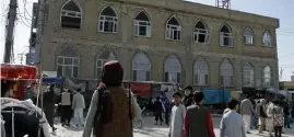  ?? Ap ?? ‘HORRIFIC’: This frame-grab image from video shows a Taliban fighter standing guard outside the site of a bomb explosion inside a mosque in Mazar-e-Sharif province, Afghanista­n, Thursday.