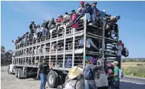  ?? PHOTO: REUTERS ?? Hitching a ride . . . A group of migrants, part of a caravan of thousands travelling from Central America on the way to the United States, travel in a chicken truck heading to Irapuato from Queretaro, Mexico, yesterday.