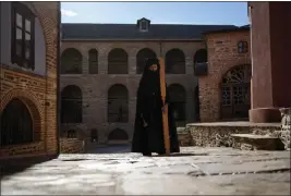  ?? ?? A monk using a mallet and plank to summon monks and visitors to the afternoon prayers pauses at the Pantokrato­r Monastery in the Mount Athos, northern Greece, Oct. 13.