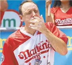  ?? JAMES KEIVOM/DAILY NEWS ?? Joey Chestnut chows down on one of the 74 hot dogs he polished off Wednesday in Coney Island.