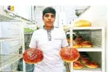  ??  ?? Iranian baker Hasan, 17, poses with loaves of bread in Tehran.