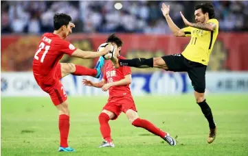  ??  ?? Tianjin Quanjian’s Kwon Kyungwon (left) fights for the ball with Guangzhou Evergrande’s Ricardo Goulart (right) during the AFC Champions League round of 16 match in Tianjin. — AFP photo