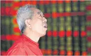  ?? REUTERS ?? An investor looks at an electronic board showing stock informatio­n at a brokerage house in Shenyang, Liaoning province, China.