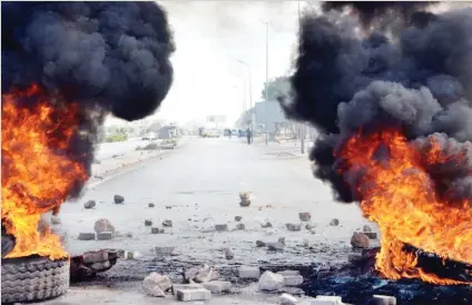  ??  ?? Tires set on fire block the road in Ben Guerdane to show solidarity with protests in the central Tunisian town of Kasserine. (AFP)