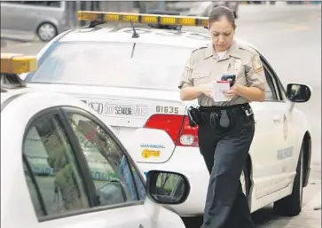  ?? Al Seib
Los Angeles Times ?? A LOS ANGELES traffic officer returns to her car. About 4.2 million California­ns have had their driver’s licenses suspended over the last eight years after failing to pay escalating traffic fees and fines.