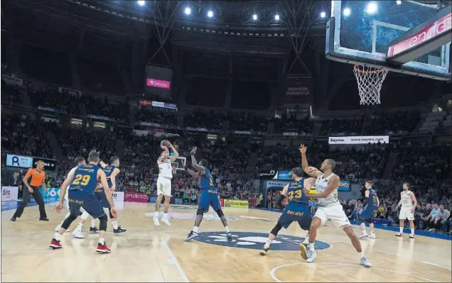  ??  ?? Gabriel Deck tira a seis metros de la canasta para darle la victoria al Real Madrid en el Buesa Arena en el último segundo. Eric, del Baskonia, no puede frenar su lanzamient­o.