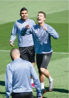  ?? — AFP ?? Real Madrid’s Portuguese forward Cristiano Ronaldo (R) gestures beside Real Madrid’s Brazilian midfielder Casemiro during a training session at Valdebebas Sport City in Madrid on Monday.