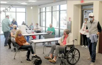  ?? Keith Bryant/The Weekly Vista ?? Volunteers stay busy as patients fill out a room at Mercy Bella Vista for Cornerston­e Pharmacy’s vaccine clinic last week.