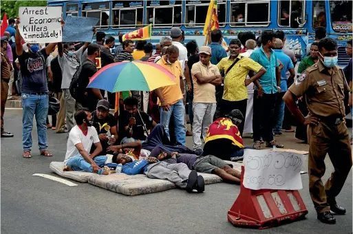  ?? AP ?? Sri Lankans protesting the country’s economic crisis lie on the road outside Prime Minister Mahinda Rajapaksa’s official residence, demanding the government step down, in Colombo on Sunday.