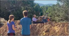  ?? FACEBOOK ?? People look on as Lore and Liz Bamberg sit on top of their recently built blockade of the trail.