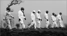  ?? ASSOCIATED PRESS ?? MEMBERS OF THE CALIFORNIA ARMY NATIONAL GUARD search a property for human remains