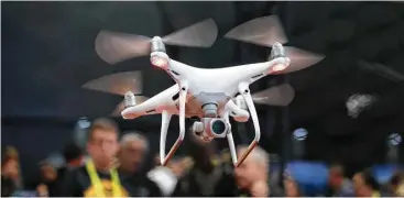  ?? Jae C. Hong / Associated Press ?? An exhibitor demonstrat­es a drone flight at CES Internatio­nal in Las Vegas. President Donald Trump gave the go-ahead to a test program to increase government and commercial use of the unmanned aircraft.