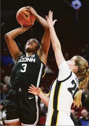  ?? Craig Mitchelldy­er / Associated Press ?? UConn’s Aaliyah Edwards, left, shoots over Iowa guard Kate Martin during the first half on Sunday.