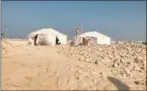  ?? ?? Site tents in background as archaeolog­ist Dalaa Kuzbari surveys the Ain Muhammad site.