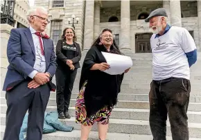  ?? ROBERT KITCHIN/STUFF ?? Taranaki man Peter Marra, right, delivers a petition to Green MP Dr Elizabeth Kerekere, and Labour MP Greg O’connor, who is also a cancer survivor, on the steps of Parliament in Wellington yesterday. Marra hopes to have the screen age for bowel cancer dropped to 45.