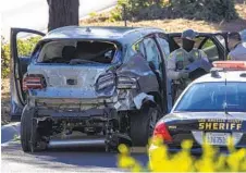  ?? DAVID MCNEW GETTY IMAGES ?? Los Angeles County sheriff ’s deputies gather evidence from the SUV that Tiger Woods was driving when it crashed Tuesday morning as he headed to the Rolling Hills Country Club for a photo and video shoot.