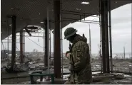  ?? EVGENIY MALOLETKA — THE ASSOCIATED PRESS ?? A Ukrainian serviceman patrols an area near the Antonovsky Bridge which was destroyed by Russian forces after withdrawin­g from Kherson, Ukraine, on Thursday.