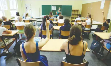  ?? FABRIZIO BENSCH / REUTERS ?? Students at a high school in Berlin, Germany, wear face masks during a lesson
on their first day back after the summer holidays earlier this month.