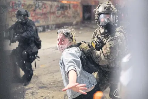  ??  ?? NO ESCAPE: Federal officers arrest a protester after she crossed a fence line set up in Portland, Oregon, last week.