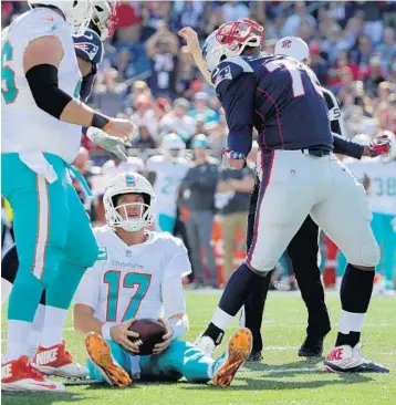  ?? ELISE AMENDOLA/AP ?? Patriots defensive tackle Adam Butler celebrates after sacking Miami Dolphins quarterbac­k Ryan Tannehill during the second half Sunday in Foxborough, Mass.