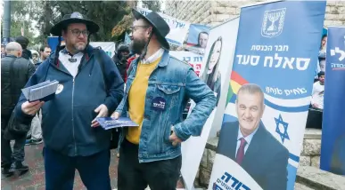  ?? (Marc Israel Sellem/The Jerusalem Post) ?? LABOR SUPPORTERS ply their wares outside a primary polling station yesterday in Jerusalem.