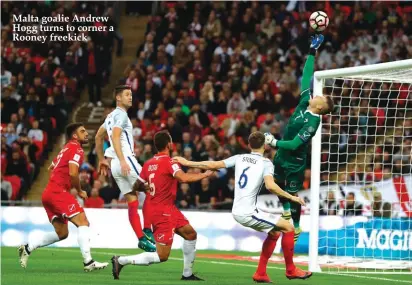  ??  ?? Malta goalie Andrew Hogg turns to corner a Rooney freekick
