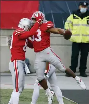  ?? JAY LAPRETE — THE ASSOCIATED PRESS ?? Ohio State running back Master Teague, right, celebrates his touchdown against Indiana with teammate Luke Farrell during the first half of an NCAA college football game Saturday, Nov. 21, 2020, in Columbus, Ohio.