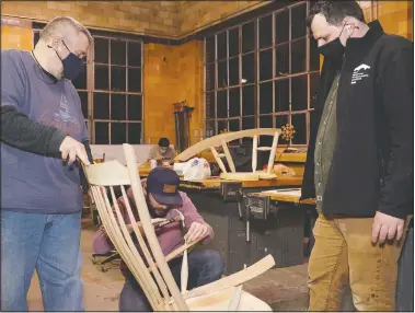  ??  ?? Jeff Rawlings (left) steadies a chair made by Caleb Peper (center) while Luke Barnett, director of the Sam Beauford Woodworkin­g Institute, looks on at the shop in Adrian, Mich. Rawlings and Peper are students in the Furniture Making and Wood Design class at the institute.
(The Daily Telegram/Mike Dickie)