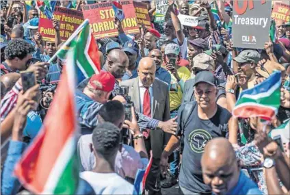  ??  ?? Schemer: Citizens occupied Church Square, outside the treasury, over President Jacob Zuma’s Cabinet reshuffle when Gupta-tainted Malusi Gigaba replaced Pravin Gordhan (centre) as finance minister. Photo: Hanna Brunlöf